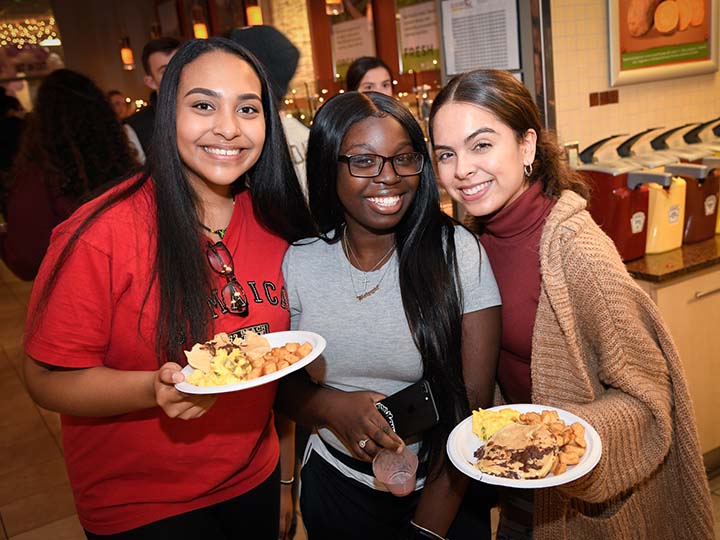 Students enjoy breakfast food in the dining hall.