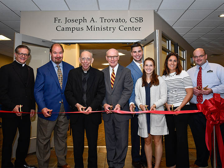Students, staff and administrators join Fr. Joe Trovato (center) to cut the ribbon on the new Fr. Joseph A. Trovato, CSB Campus Ministry Center.