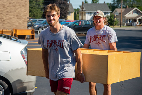 Students carrying furniture as part of community service.