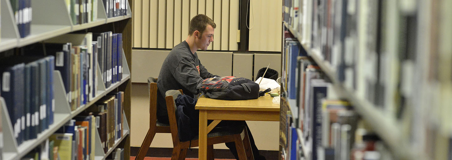 Student at table studying in library