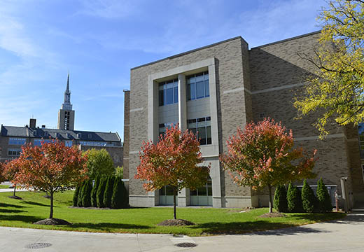 School of Pharmacy and Kearney Hall steeple with fall trees.