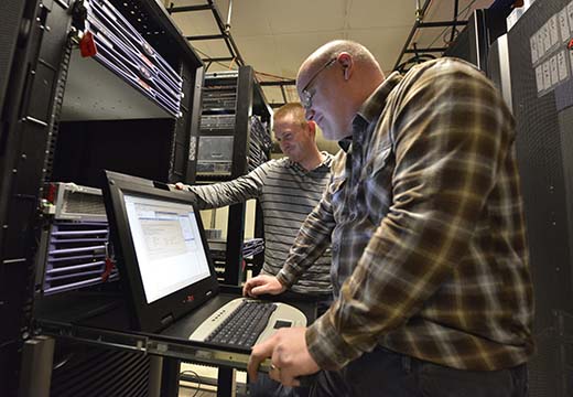 Two IT workers looking at computer servers.